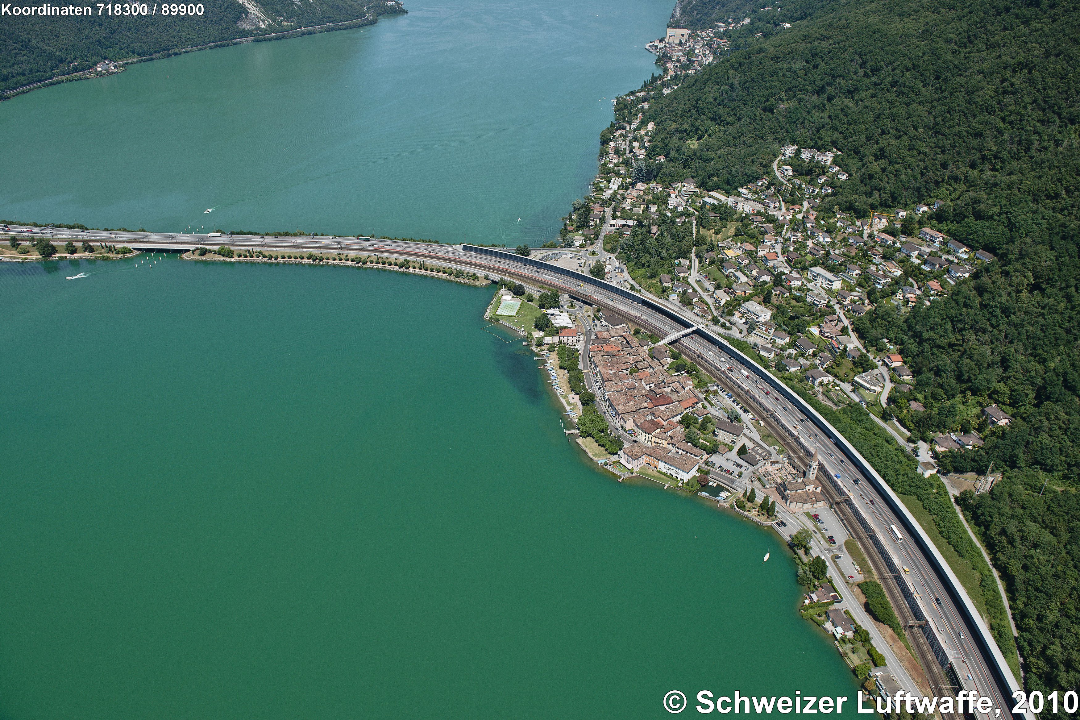 Ort am Luganer-See: Bissone, hinter der Autobahn A2 (Chiasso - Basel): Bissone-Roncato. Damm von Melide.Ortschaft ganz oben im Bild: Campione (Italien), Casino di Botta
