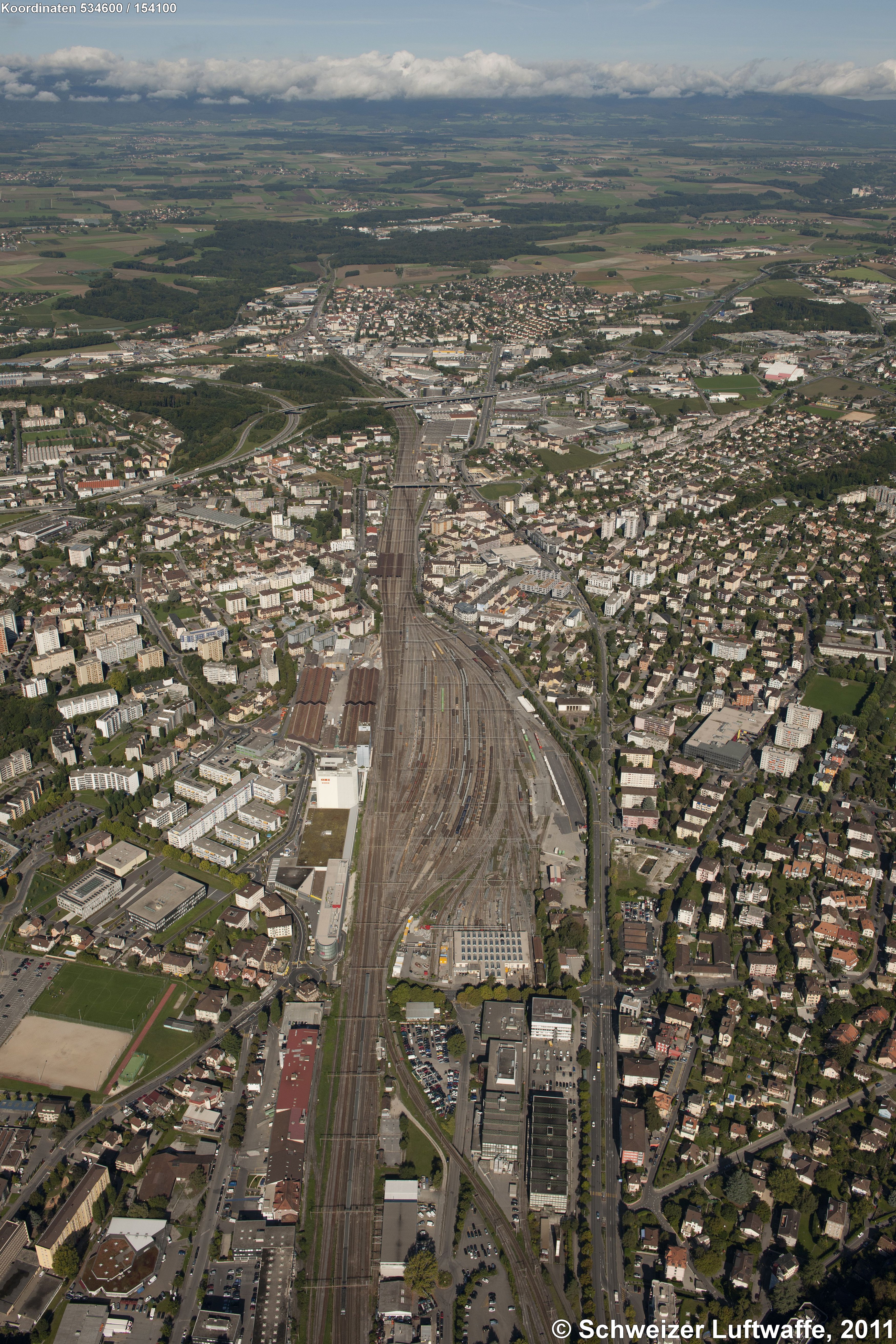 Lausanne Renens, Güterbahnhof (Blickrichtung NW; Position: 2'534'607.58, 1'154'154.59). Bildmitte: Autobahnbrücke A1; dahinter: Stadtteil Bussigny.